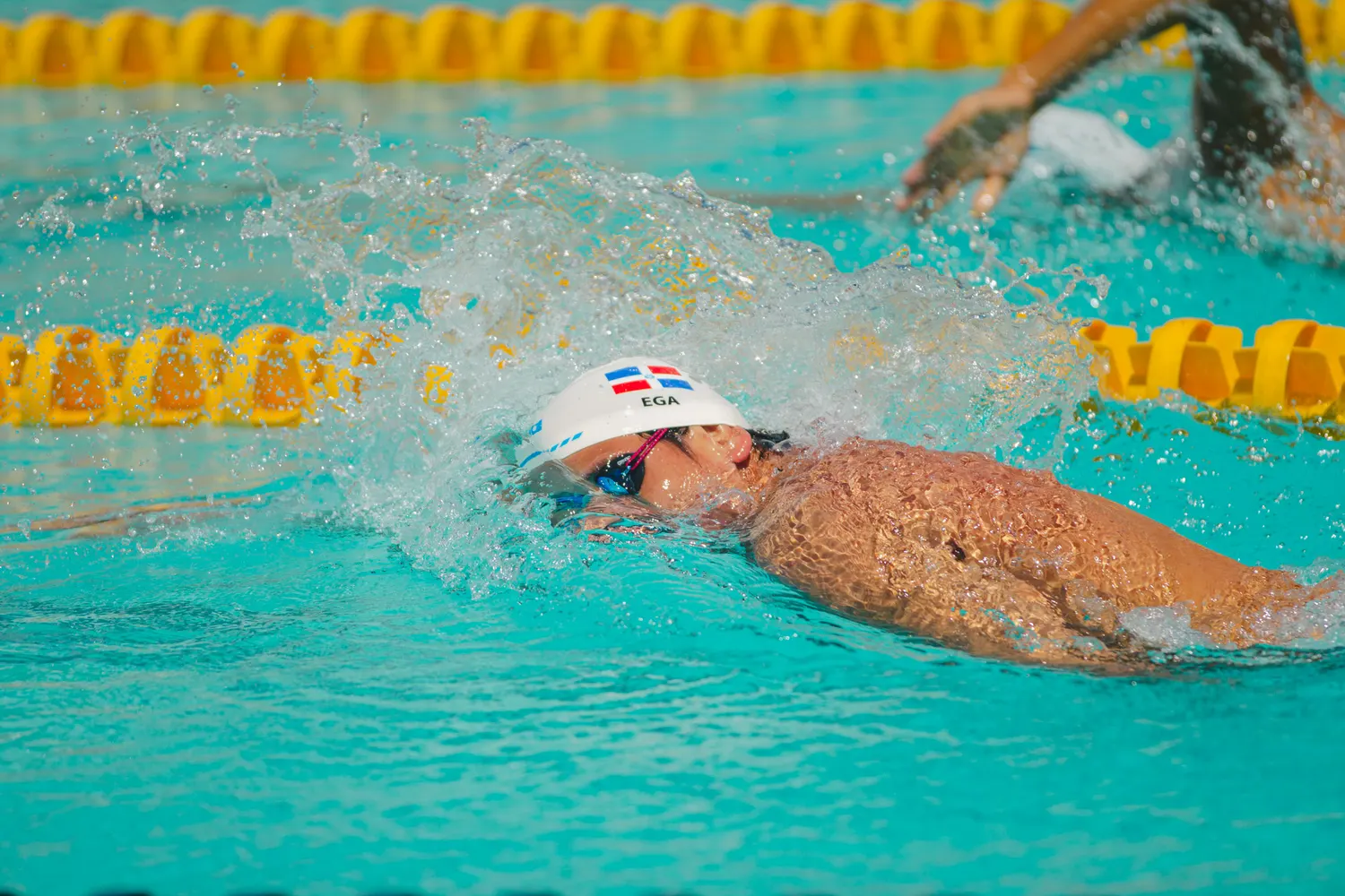 Brazada de estilo libre en aguas turquesa durante una competencia.